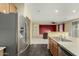 Bright kitchen showcases stainless steel refrigerator, tile floors, wood cabinets and opens to the living area at 4429 W Paseo Way, Laveen, AZ 85339