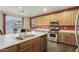 The kitchen has wood cabinets, stainless steel appliances, an island with a double sink, and a dining area at 4429 W Paseo Way, Laveen, AZ 85339