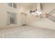 Bright living room featuring high ceilings, an elegant chandelier, and a staircase at 4429 W Paseo Way, Laveen, AZ 85339