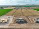 Aerial view of acre homesites under construction surrounded by farmland and mountains at 7259 S 221St Ave, Buckeye, AZ 85326