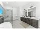 Elegant bathroom with a glass-enclosed shower, double vanity, modern lighting, and clean lines at 7259 S 221St Ave, Buckeye, AZ 85326