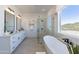 Contemporary bathroom with a soaking tub, glass shower, double vanity, and serene natural light at 7271 S 221St Ave, Buckeye, AZ 85326