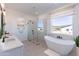 Modern bathroom featuring a soaking tub, glass-enclosed shower, dual sinks and ample natural light at 7271 S 221St Ave, Buckeye, AZ 85326