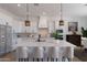 Bright, open kitchen with a spacious island, white cabinetry, pendant lights and stainless steel appliances at 7271 S 221St Ave, Buckeye, AZ 85326
