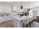 Open kitchen with a center island with barstool seating, stylish lighting and stainless steel appliances at 7271 S 221St Ave, Buckeye, AZ 85326