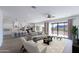 Open-concept living room with view to the kitchen and outdoor patio, modern furniture, and ample natural light at 7271 S 221St Ave, Buckeye, AZ 85326