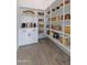 Walk-in pantry with built-in shelving and cabinets for storing food and cooking supplies at 7283 S 221St Ave, Buckeye, AZ 85326