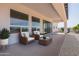 Relaxing outdoor patio with comfortable seating, a stone landscape, and sliding glass doors to the home at 7283 S 221St Ave, Buckeye, AZ 85326