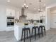 Modern kitchen features stainless steel appliances, island with seating, and modern pendant lighting at 7295 S 221St Ave, Buckeye, AZ 85326