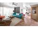 Bright living room featuring a stylish teal couch, terracotta tile floors, and mid-century modern furniture at 7740 E Heatherbrae Ave # 5, Scottsdale, AZ 85251