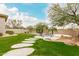 Expansive backyard with lush green grass, stone pathway, and a refreshing pool area at 7829 E Softwind Dr, Scottsdale, AZ 85255
