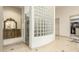 Bathroom boasts a glass block wall, custom vanity, and doorway to a large walk-in closet at 7829 E Softwind Dr, Scottsdale, AZ 85255