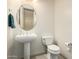 A simple powder room showcasing a pedestal sink, toilet, and neutral décor at 7829 E Softwind Dr, Scottsdale, AZ 85255