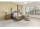Bright bedroom with a four-poster bed, plantation shutters, and cozy seating area at 7829 E Softwind Dr, Scottsdale, AZ 85255