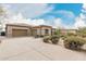 Exterior shot features a neutral-colored home, a spacious three car garage, and desert landscaping at 7829 E Softwind Dr, Scottsdale, AZ 85255