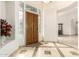 Bright foyer features a unique tile design, a custom front door, and sidelights and transom window at 7829 E Softwind Dr, Scottsdale, AZ 85255