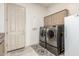 Well-lit laundry room features front load washer and dryer plus storage cabinets at 7829 E Softwind Dr, Scottsdale, AZ 85255