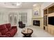 Bright living room featuring a fireplace, built-in shelving, and comfortable seating near shuttered windows at 7829 E Softwind Dr, Scottsdale, AZ 85255