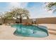 Inviting pool featuring a rock waterfall and basketball hoop at 7829 E Softwind Dr, Scottsdale, AZ 85255