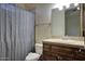 Traditional bathroom featuring a shower with a grey curtain, wood vanity and large mirror at 9443 E Taro Ln, Scottsdale, AZ 85255