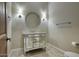 Chic bathroom featuring a modern vanity with a decorative mirror, sconce lighting, and tile flooring at 9443 E Taro Ln, Scottsdale, AZ 85255