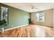 Bright bedroom featuring hardwood floors, a ceiling fan, large windows and a large green accent wall at 10762 W Cimarron Dr, Peoria, AZ 85373