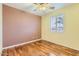 Bedroom with hardwood floors, a ceiling fan, and a window with shutters at 10762 W Cimarron Dr, Peoria, AZ 85373