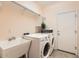 A functional laundry room includes washer, dryer, sink, and shelving for an organized space at 10762 W Cimarron Dr, Peoria, AZ 85373