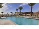 Resort-style pool area with lounge chairs, palm trees, and a covered outdoor seating space at 10762 W Cimarron Dr, Peoria, AZ 85373