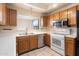 Well-lit kitchen featuring stainless steel appliances, wood cabinetry, and neutral countertops for a classic look at 10815 N 117Th Pl, Scottsdale, AZ 85259