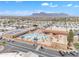 An aerial view showcases a community pool, clubhouse, and well-maintained landscaping with mountain views at 1152 S Sioux Dr, Apache Junction, AZ 85119