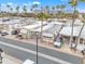 An aerial view showcases a well-maintained mobile home community with palm trees and mountain views at 1152 S Sioux Dr, Apache Junction, AZ 85119