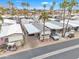 Aerial view of the property showcasing lush palm trees, a carport, and beautifully landscaped surroundings at 1152 S Sioux Dr, Apache Junction, AZ 85119