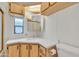 Compact bathroom featuring wood cabinetry, a clean white sink, and toilet at 1152 S Sioux Dr, Apache Junction, AZ 85119