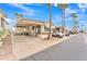 Inviting mobile home featuring a carport, front porch, and well-maintained landscaping with palm trees at 1152 S Sioux Dr, Apache Junction, AZ 85119