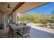 Covered patio with an outdoor dining area, ceiling fan, and desert landscaping with mountain views in the background at 11919 N 138Th St, Scottsdale, AZ 85259