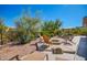 Backyard firepit area surrounded by desert landscaping, lounge chairs, and mountain views for outdoor relaxation at 11919 N 138Th St, Scottsdale, AZ 85259