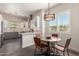 Bright kitchen with stainless steel appliances, marble countertops, white and gray cabinets, and a round breakfast table at 11919 N 138Th St, Scottsdale, AZ 85259