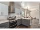 Well-lit kitchen with stainless steel stove and hood, grey cabinets, marble countertops, and open access to living area at 11919 N 138Th St, Scottsdale, AZ 85259