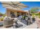 Expansive outdoor patio area with comfortable seating, a grill, and desert landscaping in the background and blue skies at 11919 N 138Th St, Scottsdale, AZ 85259