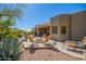 Outdoor patio with a firepit, comfortable lounge chairs, desert landscaping, and partial view of the exterior of home at 11919 N 138Th St, Scottsdale, AZ 85259