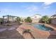 Inviting backyard featuring a freeform pool, a pergola, and ample desert landscaping at 12926 W Pershing St, El Mirage, AZ 85335