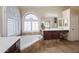 Luxurious bathroom featuring a soaking tub and arched window at 12926 W Pershing St, El Mirage, AZ 85335