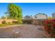 Large gravel backyard featuring mature trees and privacy fencing at 12947 W Mauna Loa Ln, El Mirage, AZ 85335