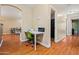 Hallway with laminate flooring, a white desk and a green office chair at 12947 W Mauna Loa Ln, El Mirage, AZ 85335