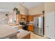 Well-equipped kitchen featuring wooden cabinets and modern stainless steel appliances and tile floors at 12947 W Mauna Loa Ln, El Mirage, AZ 85335