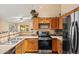 Functional kitchen with stainless steel appliances and ample counter space adjacent to a sunlit dining area at 12947 W Mauna Loa Ln, El Mirage, AZ 85335