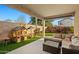 Cozy covered patio featuring outdoor seating, play area, and views of the private backyard at 12947 W Mauna Loa Ln, El Mirage, AZ 85335