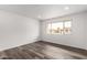 Bedroom with wood-look floors, a large window, and neutral paint at 13110 W Blue Bonnet Dr, Sun City West, AZ 85375