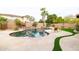 Beautiful backyard featuring a pool, lush palm trees, and a stone patio at 15146 W Highland Ave, Goodyear, AZ 85395